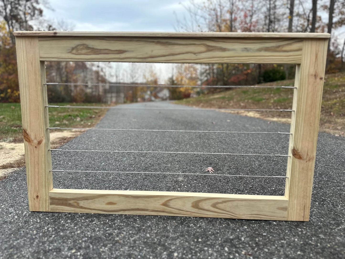 Front view of a modern cable wire patio gate, featuring 1/8β T316 stainless steel cables and a durable wooden frame, designed for outdoor decks and patios.