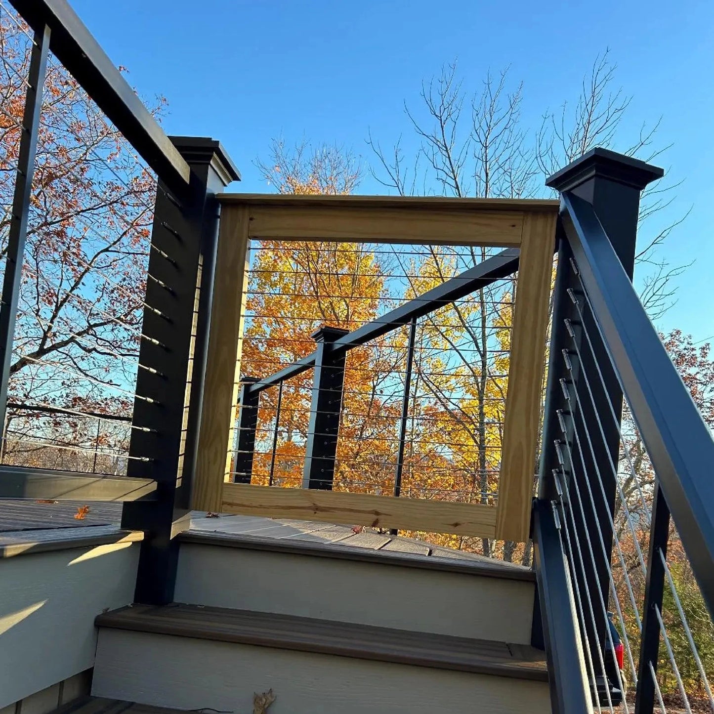 Cable wire patio gate securely installed on a wooden deck, providing a modern and durable safety solution for outdoor spaces.