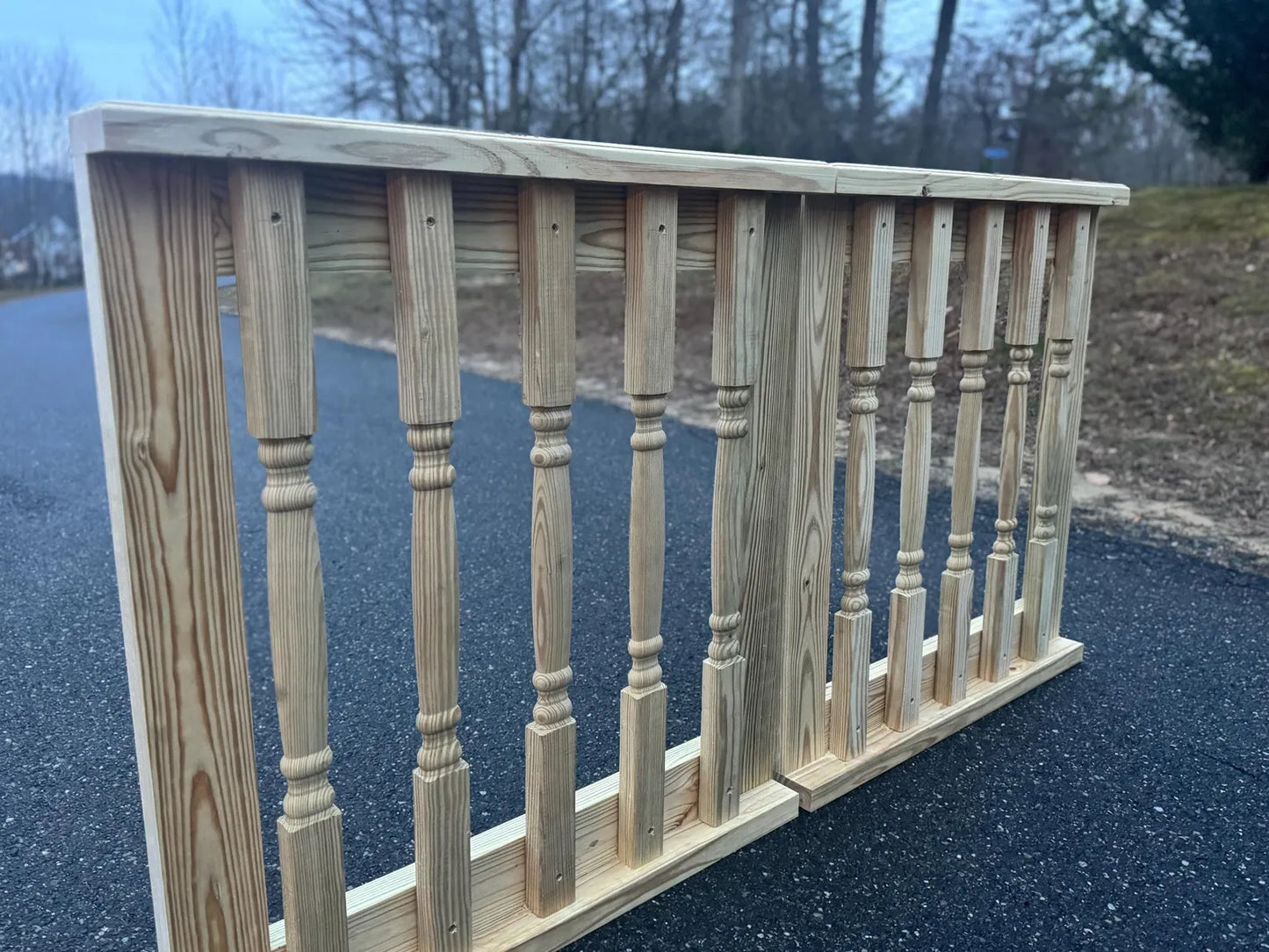 Side perspective of a double decorative wooden baluster gate, highlighting the depth and craftsmanship of the baluster detailing.