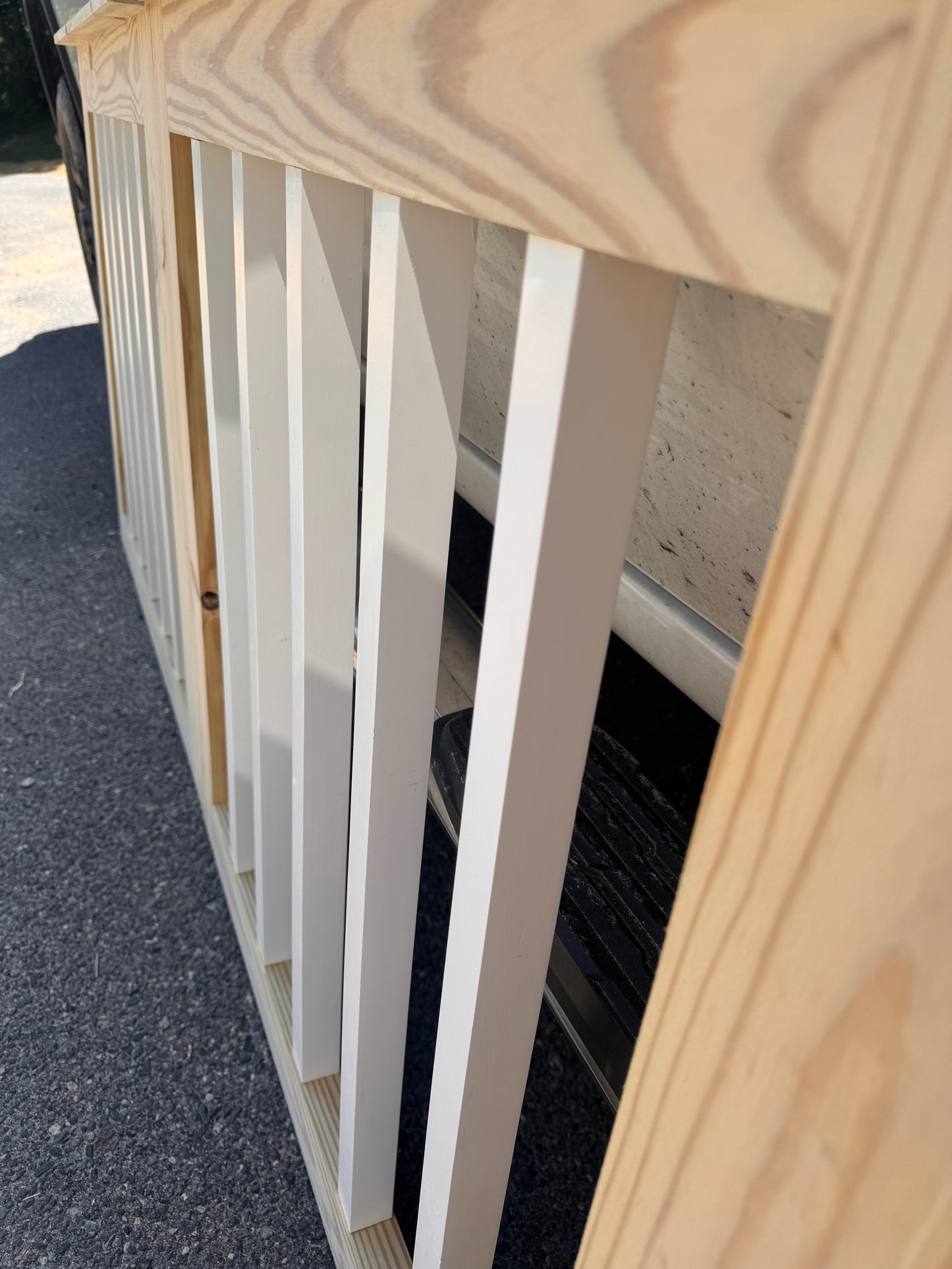 Close-up of white square balusters on custom wooden deck gate for outdoor patio